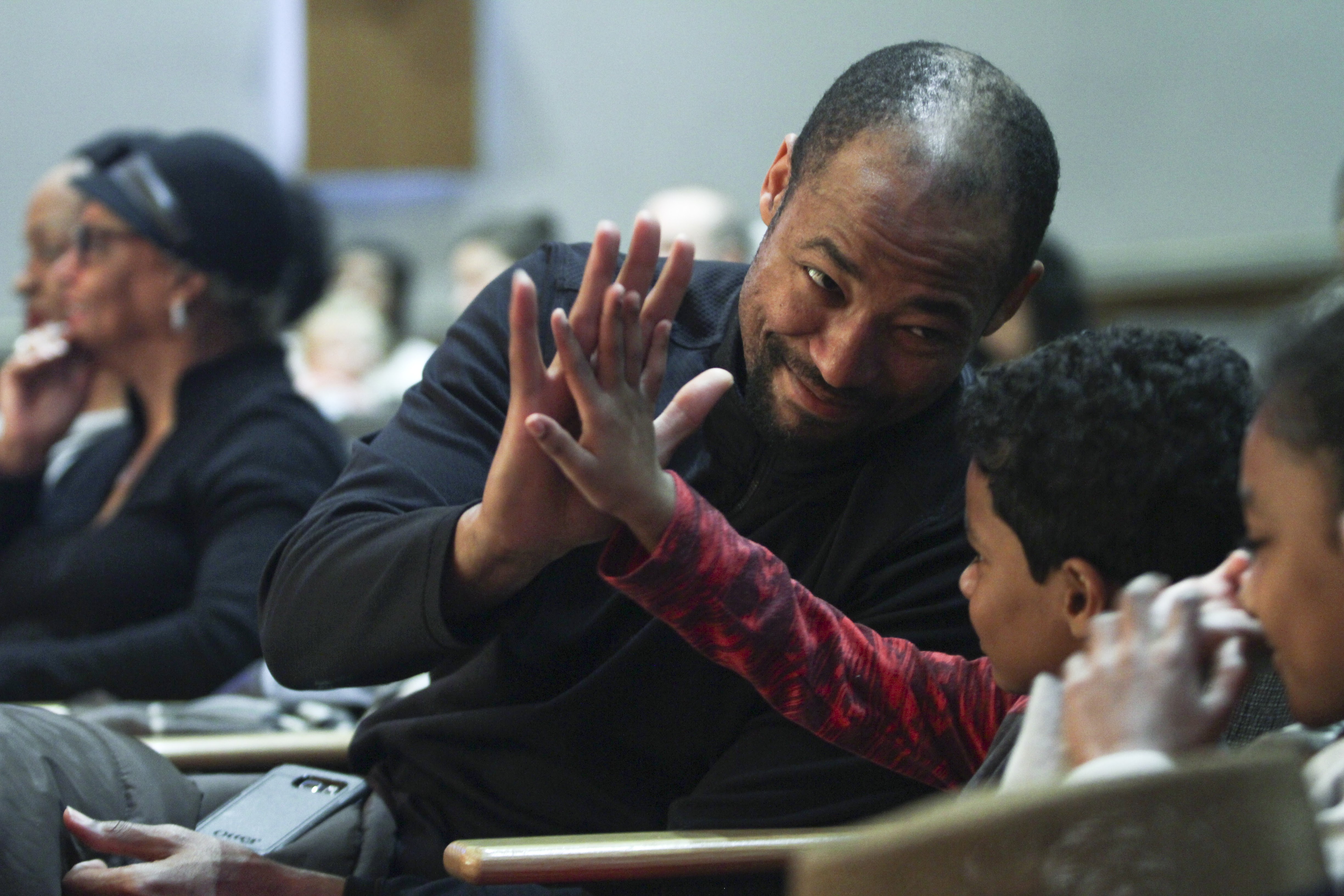 Illustrator Jerry Pinkney giving a child a high five