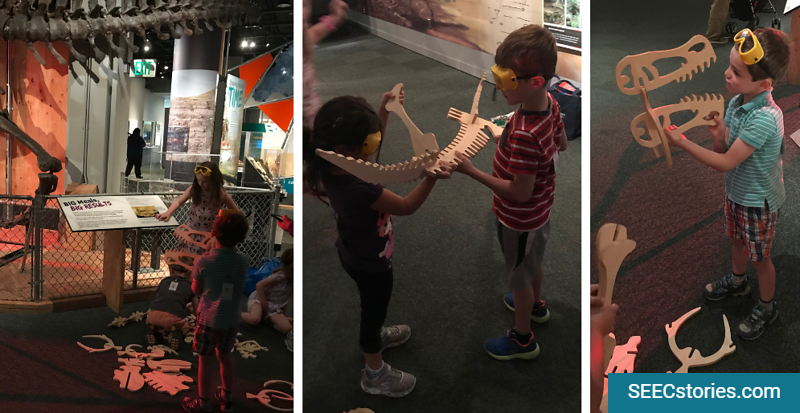 Children looking at and holding pretend dinosaur bones