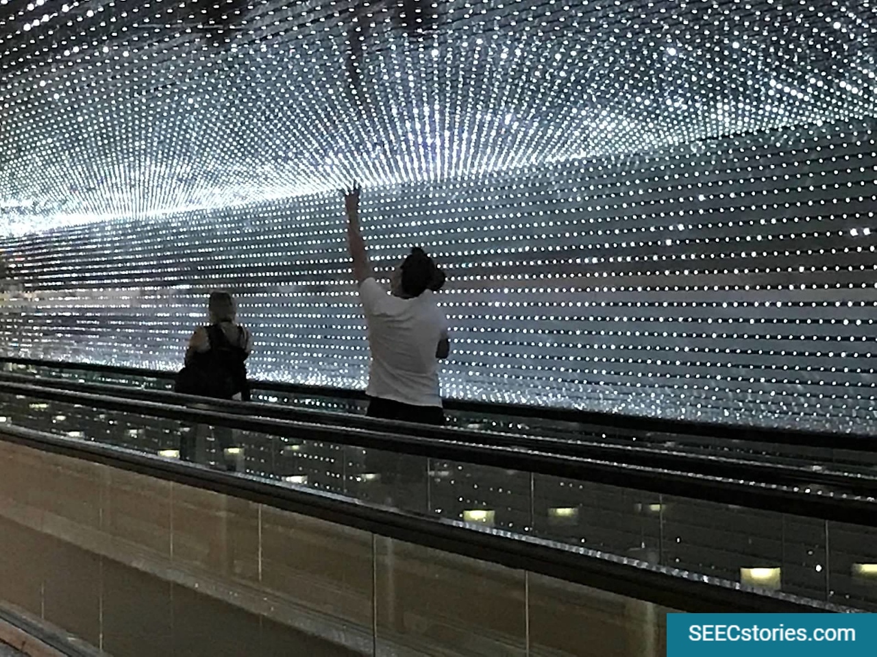 Father and daughter looking up at lights