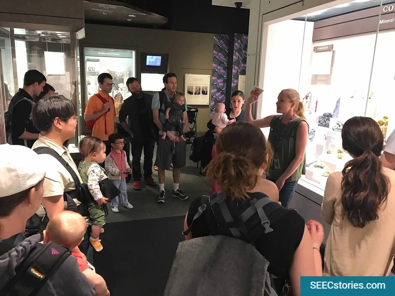 Parents standing in a circle listening to a teacher talk